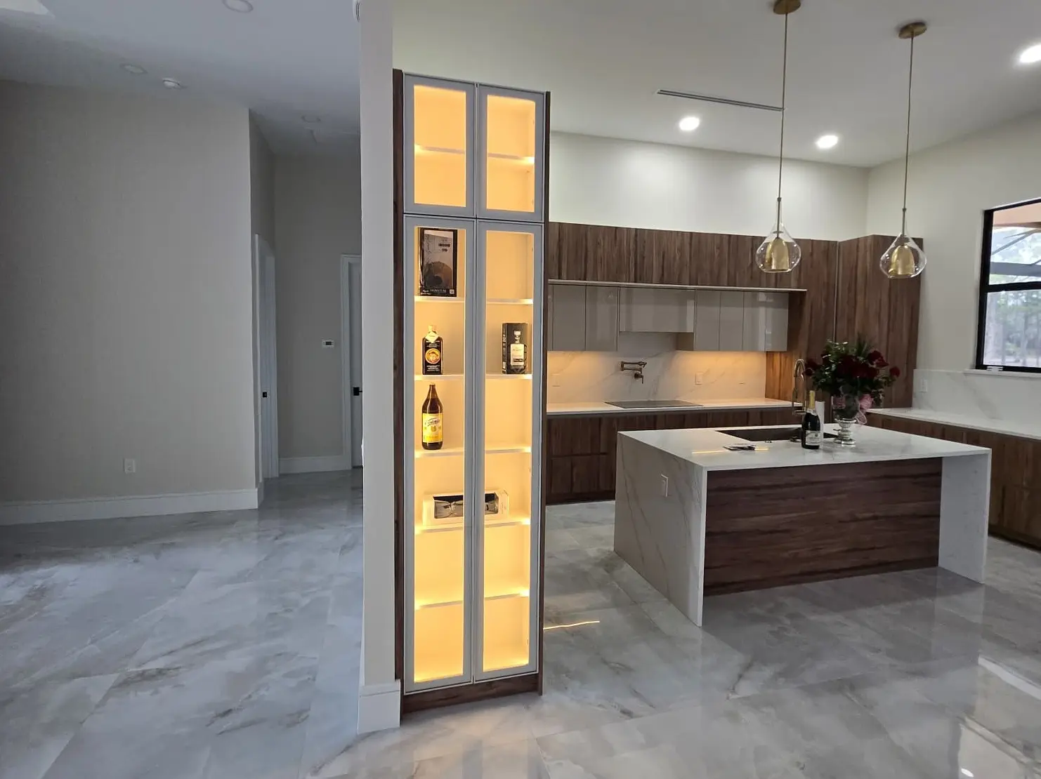Modern walnut kitchen with illuminated display cabinet and island